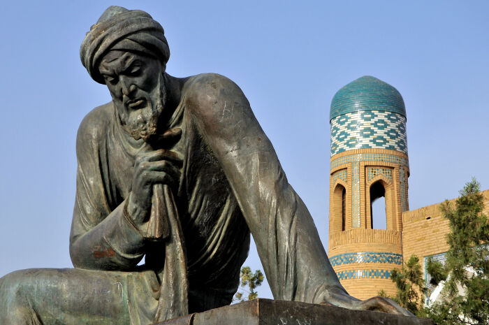  Estatua de Al-Juarismi, en las afueras de la Puerta de Poniente; detrs, el hotel (antigua madrasa) de Mohamed Amin Jan. Jiva (Uzbekistn)