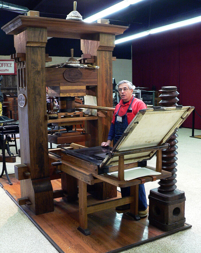 Peter Small demostrando el uso de la imprenta Gutenberg en el International Printing Museum.