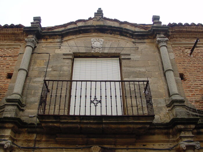 En la fotografa la puerta es adintelada y sobre ella se abre un gran balcn sobre el que est esculpida la cruz de Santiago