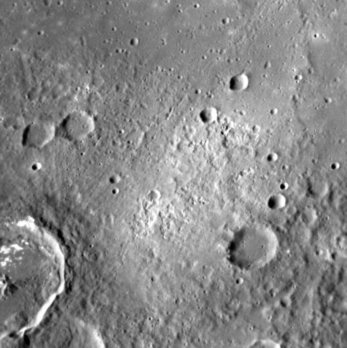 Vista oblicua del rea de alto albedo dentro del crter Raphael en Mercurio. Parte del crter Flaiano est en la esquina inferior izquierda. El rea de alto albedo est asociada con depresiones irregulares y puede ser volcnica